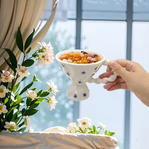 French vintage ceramic coffee goblet with blue floral patterns and twisted handle