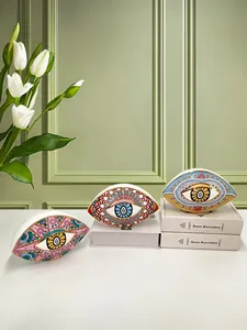 Detailed close-up of ceramic Evil Eye ornaments with intricate mandala patterns on a desk