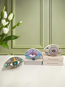 Detailed view of hand-painted evil eye ceramic decor with gold-gilded edges on display