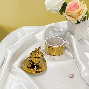 Dettaglio di un portagioie in ceramica a forma di unicorno dorato con coperchio aperto