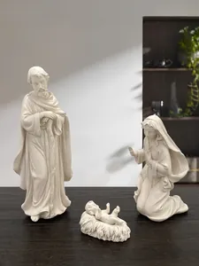 Dettaglio del presepe in resina bianca con Giuseppe, Maria e Gesù Bambino su legno scuro