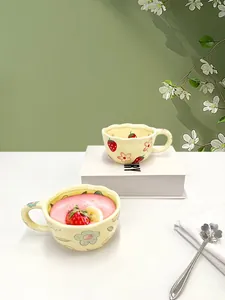 Detail of handmade strawberry ceramic mug and bowl set with wavy edges for breakfast