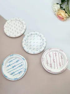 Detail of hand-painted ceramic bow dessert plates with glaze finish in pastel colors