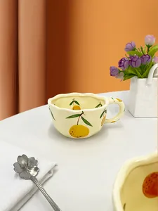 Macro detail of hand-pinched ceramic strawberry mug with irregular rim and wide handle