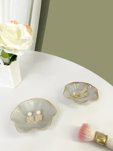 Dettaglio di vassoi per gioielli in ceramica marmorizzata con bordi dorati per anelli