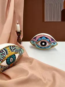 Artistic evil eye ceramic decor with gold trim and bohemian patterns on pink silk