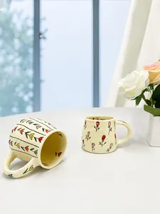 Detail of handmade ceramic mug with embossed rose pattern and large rounded handle