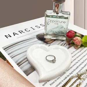 Detailed view of silver solitaire ring resting on a white heart-shaped display tray