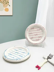 Detailed macro view of hand-painted ceramic plates with pink and blue bow patterns