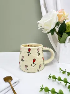 Detail of handmade ceramic mug featuring hand-painted roses and decorative interior text