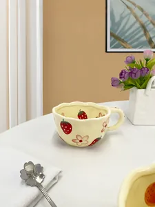 Detail of strawberry ceramic mug with scalloped edge and hand-painted floral pattern