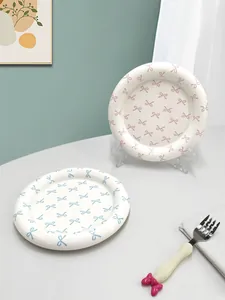 Detail of ceramic bow pattern plates with matching 3D bow handle dessert fork