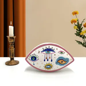 Artistic evil eye ceramic tray on table with golden candle holder and flowers