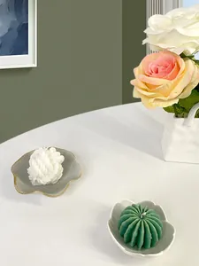 Dettaglio di vassoi per gioielli in ceramica a petalo con candele profumate decorative
