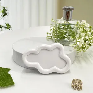Close-up of white cloud-shaped ceramic jewelry tray with smooth glazed finish and wavy edges