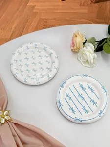 Top view of ceramic dessert plates with blue bow patterns and floral decor