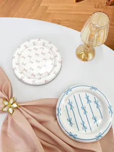 Detail of ceramic dessert plates with pink bow and blue stripe patterns in 2-piece set