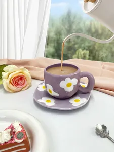 Detailed close-up of a purple ceramic coffee cup and saucer with white floral patterns