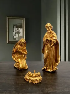 Dettaglio del presepe dorato con statuette di Giuseppe, Maria e Gesù Bambino in resina