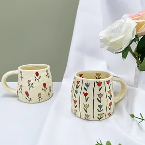 Handcrafted ceramic coffee mugs with floral rose and tulip patterns in cream yellow