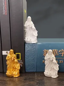 Detailed resin figurines of a Mexican family in gold and white on a bookshelf
