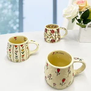 Handcrafted ceramic mugs with hand-painted rose and tulip patterns in a cream glaze finish