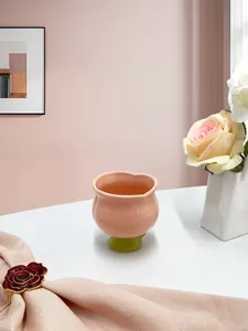 Vue détaillée du mug en céramique tulipe rose avec base verte dans un décor élégant