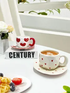Handcrafted ceramic coffee cup and saucer set with red heart patterns for afternoon tea