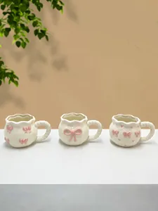 Jolie tasse à café en céramique avec nœud rose fait main, idéale pour le thé et l'usage quotidien.