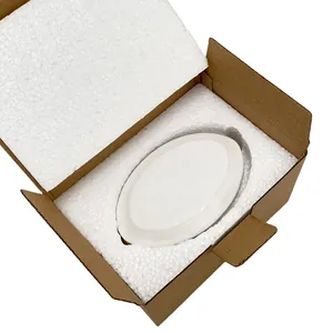 Vista de la bandeja cerámica blanca embalada en espuma protectora y caja de cartón
