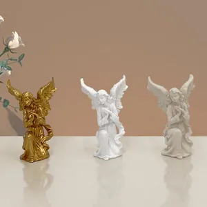 Tre statuine di angeli inginocchiati in resina in oro, bianco e grigio per l'arredo