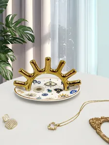 Vista detallada de la bandeja de cerámica para joyas con ojo turco y soporte oro