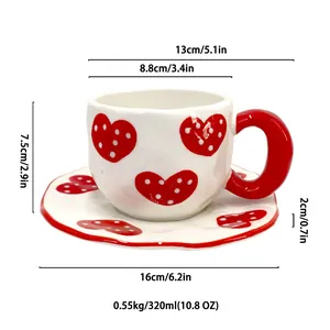 Handcrafted ceramic coffee cup and saucer set with red heart pattern and wavy edges