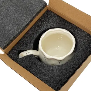 Detail of floral ceramic mug with wavy rim safely packed in protective foam padding