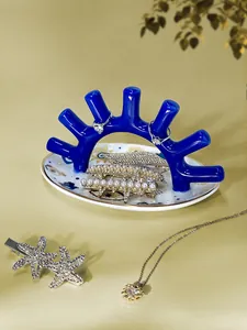 Vista detallada de un soporte para joyas de coral en una bandeja de cerámica