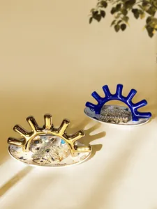 Detalle de bandeja de cerámica para joyas ojo turco con soportes de pestañas oro y azul