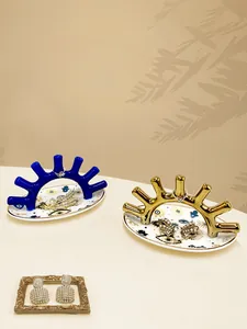 Detalle de bandejas para joyas de ojo con portaanillos en forma de coral azul y oro