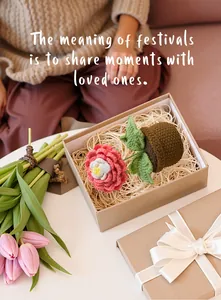 Handmade crochet pink peony flower in a woven pot inside a kraft paper gift box