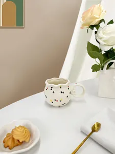 Detailed view of floral ceramic mug with wavy rim on a breakfast table setting