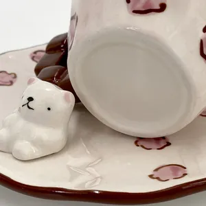 Dettaglio del piattino in ceramica con orsetto 3D e motivi decorativi di nuvole rosa