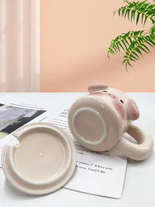 Dettaglio di una tazza in ceramica rosa maialino 3D con coperchio coordinato e decorazioni