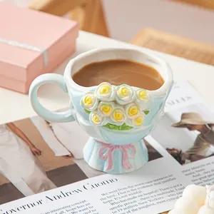 Handgefertigte Keramik-Kaffeetasse mit Tulpenrelief und rosa Schleife auf dem Tisch