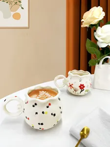 Artistic ceramic mugs with wavy edges and floral patterns for cozy afternoon coffee time