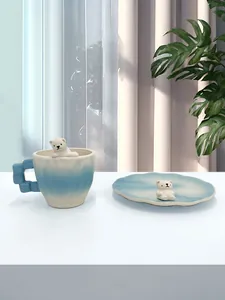 Dettaglio del simpatico orso polare 3D in ceramica su tazza e piattino sfumato blu e bianco