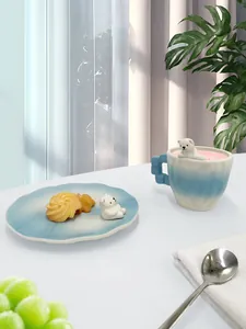 Dettaglio tazzina in ceramica con orsetto polare 3D su piattino marmorizzato azzurro