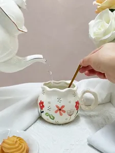 Close-up of wavy rim ceramic coffee mug with floral pattern and spiral handle detail