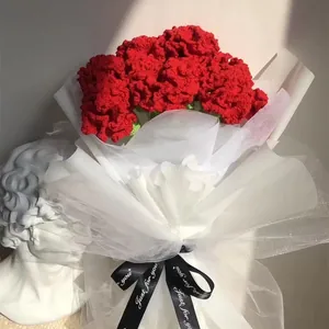 Dettaglio di bouquet di garofani rossi fatti a mano con elegante carta regalo in rete