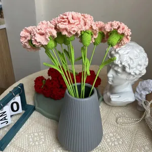 Garofani rosa fatti a mano all'uncinetto in vaso di ceramica grigia con decori chic
