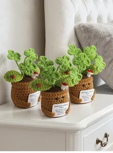 Close-up van handgemaakte gehaakte potplanten met motiverende kaarten en schattige lachende gezichtjes