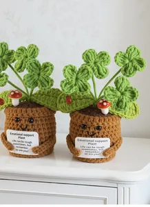 Detail van handgehaakte klaverplant met motiverende kaart en schattig gezichtje erop